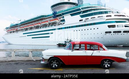 Havana, Cuba - 25 luglio 2018: Un classico rosso e bianco restaurato Chevrolet Belair parcheggiato sulla strada di fronte a una nave da crociera a Cuba Havana. Foto Stock