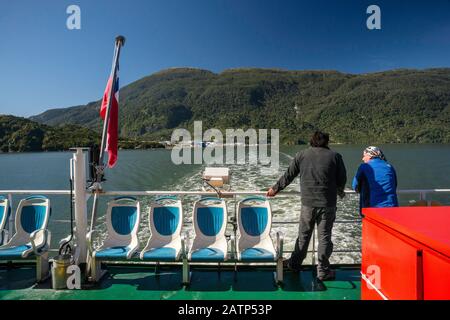 Il traghetto Quelat lascia la sua scia in Aisen Fjord, Puerto Chacabuco in lontananza, Aysen Regione, Patagonia, Cile Foto Stock