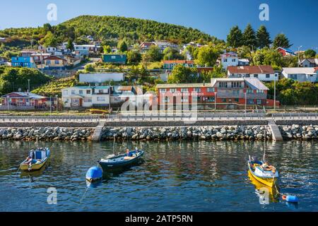 Barche a molo di Puerto Aguirre visto da un traghetto, a Isla Las Huichas, arcipelago di Islas Huichas, regione di Aysen, Patagonia, Cile Foto Stock