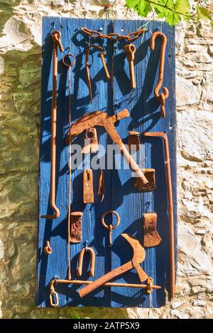 Composizione decorativa di utensili d'epoca da costruzione manuale sulla parete della casa nel villaggio di Lania. Limassol. Cipro Foto Stock