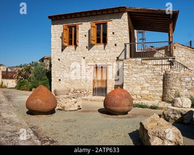 Tradizionale casa in pietra con anfore di vino di terracotta rovesciato nel cortile. Lania villaggio. Limassol. Cipro Foto Stock