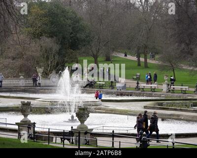 Le persone che passeggiano nei giardini italiani al sole invernale a Kensington Gardens London, Regno Unito. Foto Stock