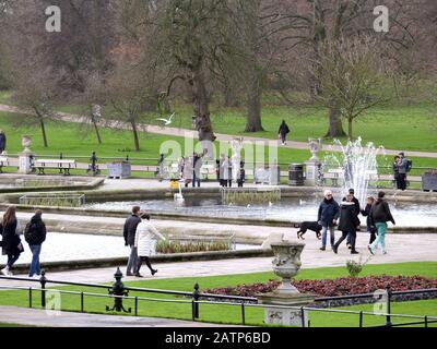 Le persone che passeggiano nei giardini italiani al sole invernale a Kensington Gardens London, Regno Unito. Foto Stock