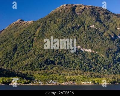 Montagna coperta con foresta pluviale temperata Valdiviana sopra il villaggio di Puerto Gaviota a Isla Magdalena, Aysen Regione, Patagonia, Cile Foto Stock