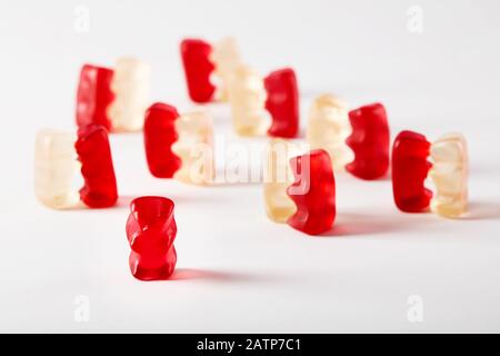 Gli orsi gummy ballano con un solo orso che è escluso. Concetto di discriminazione o di esclusione della PROM. Foto Stock