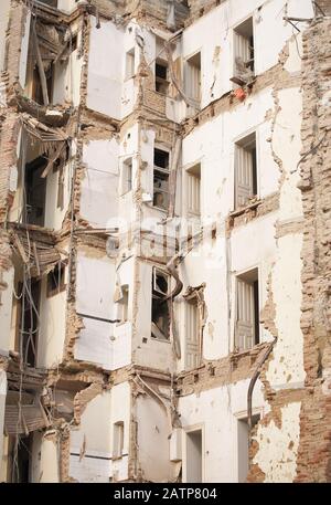 Vecchio edificio demolito a più piani con mattoni e infissi. Demolizione, ristrutturazione, sisma Foto Stock