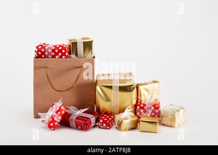Pile di scatole da regalo colorate e una borsa per lo shopping con nastri su sfondo bianco. Concetto di natale o regali speciali di giorno. Vista ravvicinata. Foto Stock
