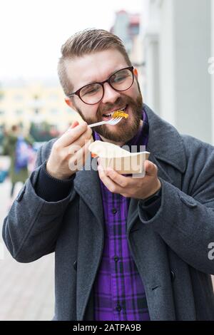 L'uomo sta tenendo un panino falafel in un sacchetto di carta. Sano Street food concetto, cucina orientale Foto Stock