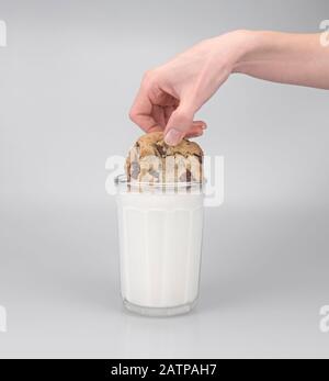 Il biscotto di cioccolato di dunking del chip nel latte Foto Stock
