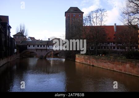 Tipici edifici di Nurnberg in Germania durante l'inverno con canale d'acqua al tramonto Foto Stock