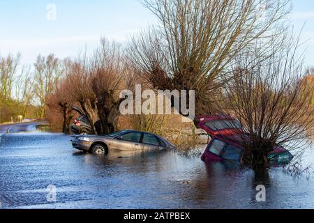 La foto datata gennaio 27th mostra le auto che sono state catturate sulla A1101 sul confine Cambridgeshire/Norfolk nelle recenti inondazioni e sono ora visibili subito dopo che le acque alluvionali sono scese. Inondare l'acqua lungo un famigerato tratto di strada a Welney sul confine Cambridgeshire/Norfolk si è placato rivelando oggi un incredibile QUATTRO auto a trefoli (Mon). Gli automobilisti sono stati tutti presi dal lungo e tortuoso tratto di strada, che è stato allagato per due mesi. Quattro persone hanno dovuto essere salvate da una delle automobili da vigili del fuoco dopo che è stato catturato a Welney Wash il 18 gennaio. Il abbandonato Foto Stock