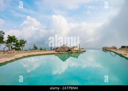Bellissima piscina sulla cima della montagna con riflessi di cielo e nuvole Foto Stock