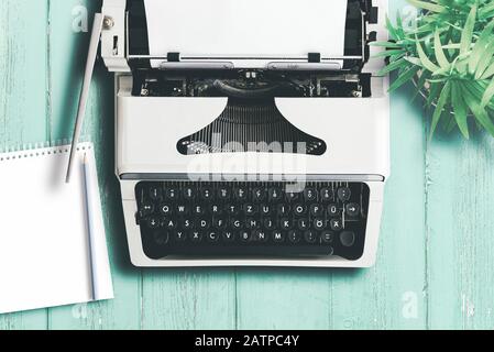 vista dall'alto della vecchia macchina da scrivere su un colorato tavolo in legno, scrittura e concetto di creazione di contenuti Foto Stock