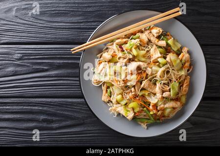 Servire bihon di pasta di riso filippino con verdure e carne primo piano in un piatto sul tavolo. Vista dall'alto orizzontale Foto Stock