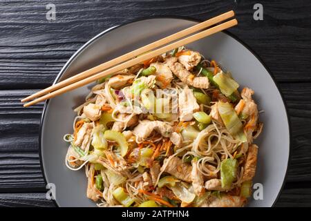 mescolare le tagliatelle di riso fritte frittelle bihon con verdure e carne da vicino in un piatto sul tavolo. Vista dall'alto orizzontale Foto Stock