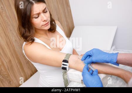 Assistente medico o infermiere prendendo un campione di sangue dalla vena del braccio della donna incinta con un vacutainer. La venipuntura o procedura venepuncture concept Foto Stock