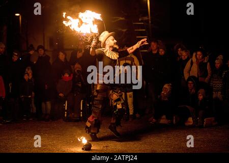 Artista di strada con un bastone che brucia durante la sua pericolosa mostra di fuoco, Ana Mraz, Festival Internazionale Winter Street Theatre a Lubiana, Slovenia Foto Stock