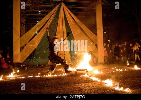 Artista di strada con un bastone che brucia durante la sua pericolosa mostra di fuoco, Ana Mraz, Festival Internazionale Winter Street Theatre a Lubiana, Slovenia Foto Stock
