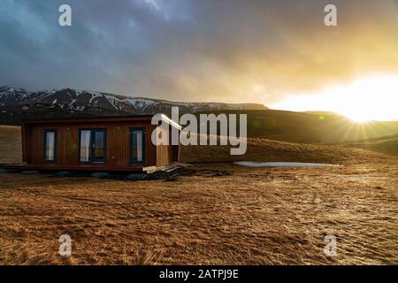 Cabina in Islanda tra le colline all'alba Foto Stock