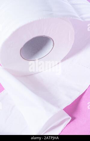 Carta igienica perforata ecologica bianca su sfondo rosa Foto Stock