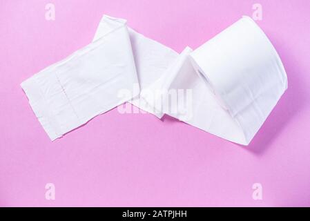 Carta igienica perforata ecologica bianca su sfondo rosa Foto Stock