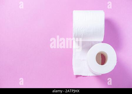 Carta igienica perforata ecologica bianca su sfondo rosa Foto Stock