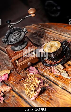 Caffè, fagioli, tazza di caffè e foglie d'autunno su una scrivania di legno, Russia Foto Stock