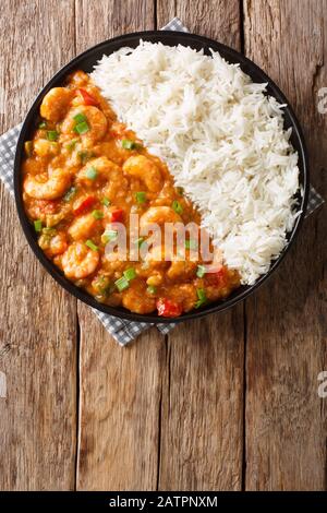 Etouffee di gamberi della Louisiana con verdure cotte in salsa roux servite con il closeup di riso in un piatto sul tavolo. Vista dall'alto verticale Foto Stock