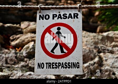 Accedi di fronte a una rovina Maya dicendo No Trespassing in inglese e spagnolo Foto Stock