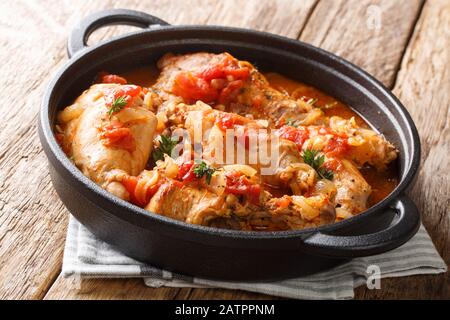 Andorra ricetta stufato di coniglio in salsa di pomodoro con vino bianco ed erbe primo piano in una padella sul tavolo. Orizzontale Foto Stock