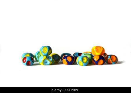Bellissimo sfondo colorato e allegro fatto a mano di perle di lampwork con punti. Le perle sono isolate su sfondo bianco. Adatto per inserto di testo. Foto Stock