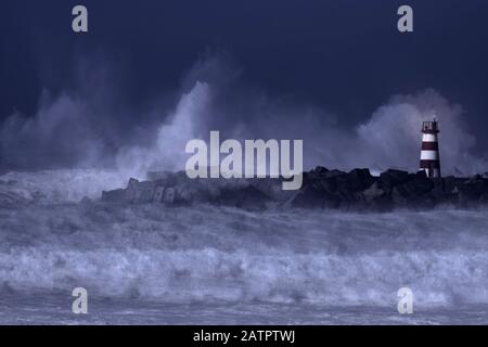 Spettacolare stagione notturna. Ingresso al porto di Povoa de Varzim durante una tempesta marina, a nord del Portogallo. Esposizione multipla. Foto Stock