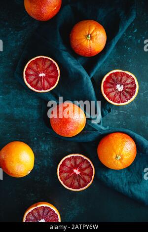 Composizione di cibo a disposizione piatta con arance sanguigne su sfondo blu scuro. Foto Stock