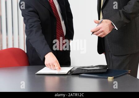 Gli uomini d' affari di discutere in un ufficio. Foto Stock