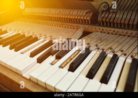 Vista dei tasti piano rotti - Polverosi e sporchi - luce Calda Foto Stock