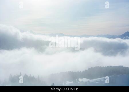 strati di nebbiosa montagna con raggi di sole che splendono attraverso Foto Stock