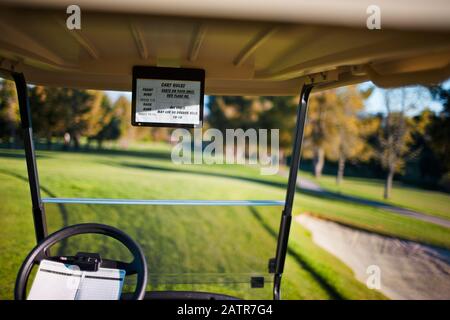 Interno di un golf cart su un campo da golf verde. Foto Stock