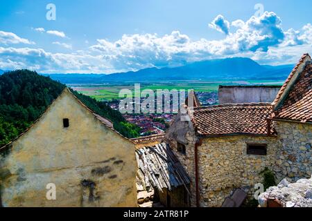 Fotografia di paesaggio scattata dalla Cittadella di Rasnov che mostra la città di Rasnov e le montagne in lontananza - Rasnov, il paese di Brasov, Transilvania, Romani Foto Stock