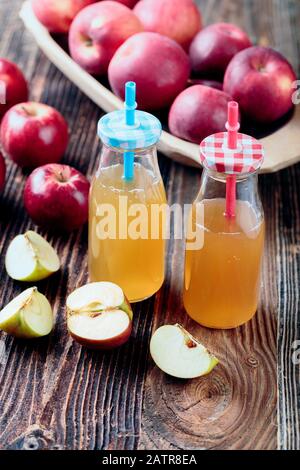 Due bottiglie di sidro di mele fresco biologico o succo di mela sul vecchio un tavolo di legno. Foto Stock