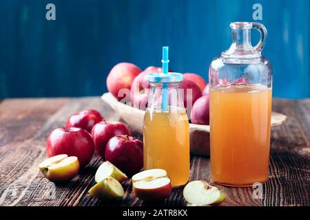 Due bottiglie di sidro di mele fresco biologico o succo di mela sul vecchio un tavolo di legno. Foto Stock