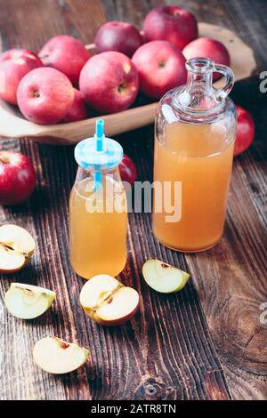Due bottiglie di sidro di mele fresco biologico o succo di mela sul vecchio un tavolo di legno. Foto Stock