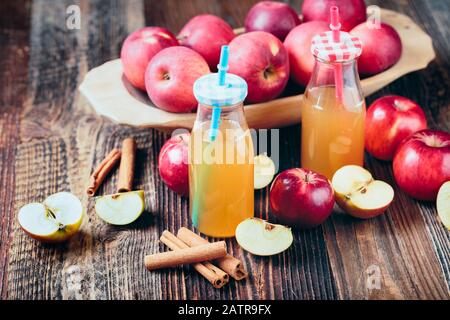 Due bottiglie di sidro di mele fresco biologico o succo di mela sul vecchio un tavolo di legno. Foto Stock