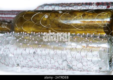 Le tre diverse bottiglie di vino a filo spazzolato. Il tradizionale artigianato decorativo. Su sfondo bianco. Foto Stock