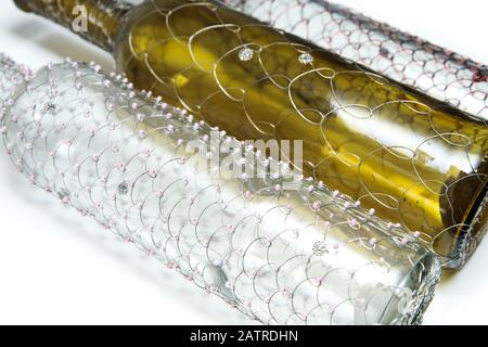 Le tre diverse bottiglie di vino a filo spazzolato. Il tradizionale artigianato decorativo. Su sfondo bianco. Foto Stock