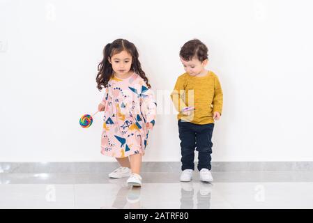 Due Giovani Bambini Che Corrono Verso La Fotocamera In Casa. Foto Stock