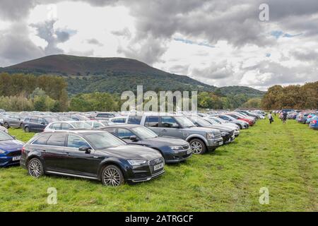 Auto parcheggiate nel campo per Abergavenny Food Festival con la Blorenge in lontananza, Galles, Regno Unito Foto Stock