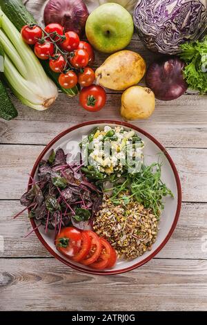 Insalata vegetariana a colpo verticale con fagioli, verdure, foglie di barbabietole, semi germogliati, germogli di piselli verdi. Vista dall'alto. Spazio di copia Foto Stock