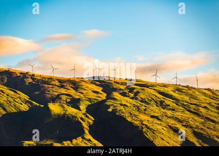 Turbine eoliche in fila lungo un crinale di un paesaggio aspro, vicino Kihei: Kihei, Maui, Hawaii, Stati Uniti d'America Foto Stock