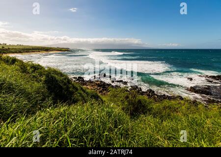 Lussureggiante fogliame verde e vista delle onde e della spiaggia di Ko'okipa dal punto di osservazione ho'okipa lungo la costa della North Shore, vicino a Paia Foto Stock