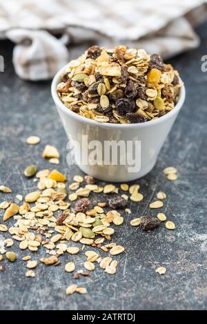 Colazione a base di cereali sani. Muesli misti in ciotola su vecchio tavolo da cucina. Foto Stock